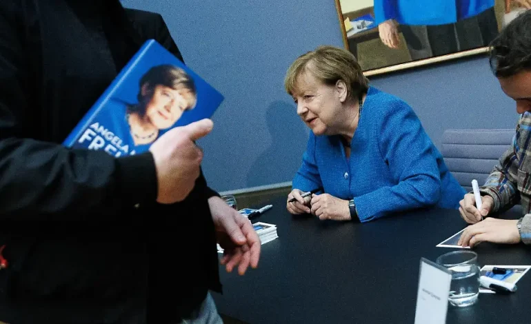 Merkel signiert Kunstpostkarten ihres Porträts im Bode-Museum